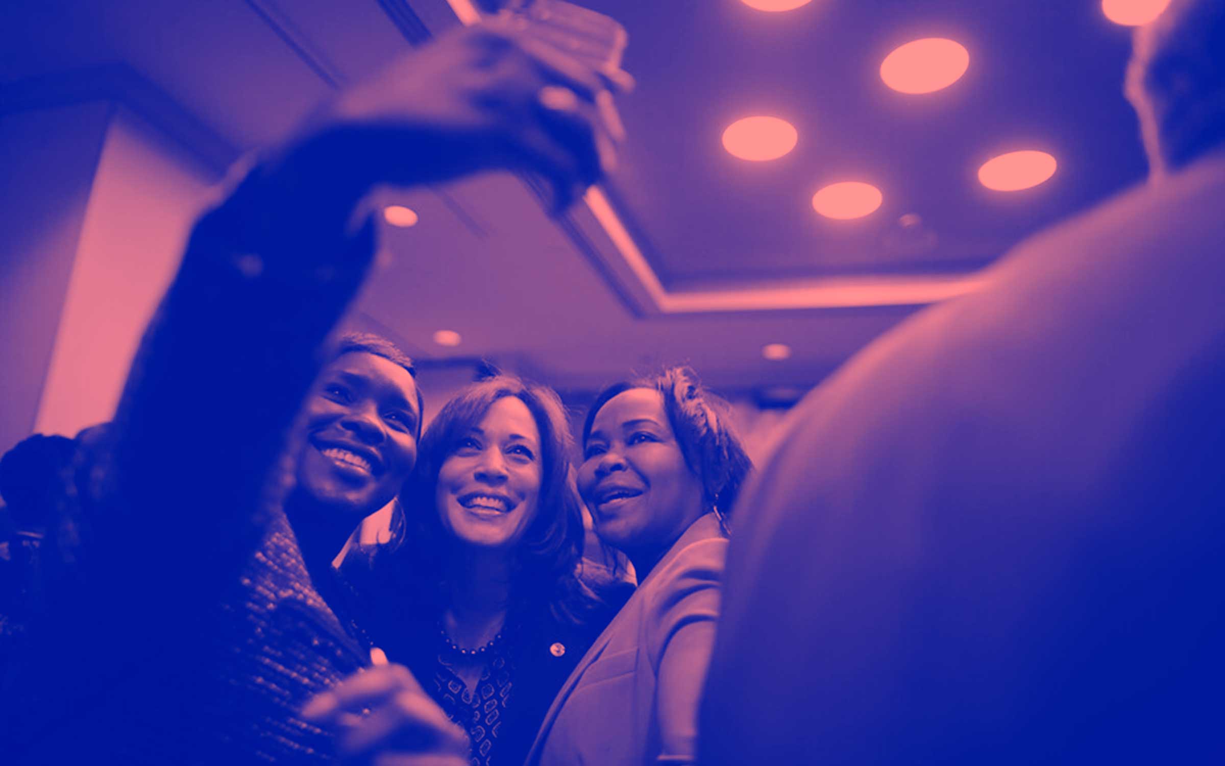 Kamala Harris in between two other Black women taking a group selfie.