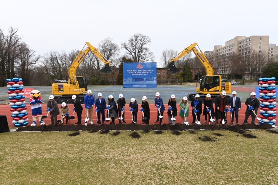 17 people in hard hats with shovels breaking ground for Meltzer Center. Mascot Clawed Z. Eagle also stands with them.
