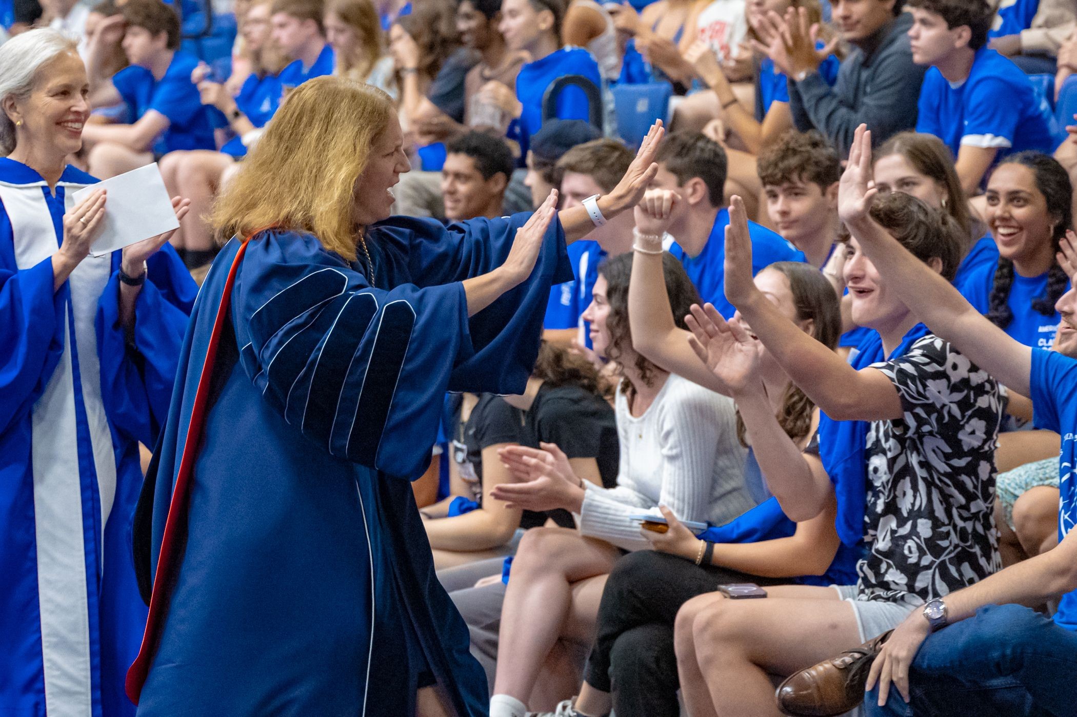 President Sylvia M Burwell high-fiving students at Convocation
