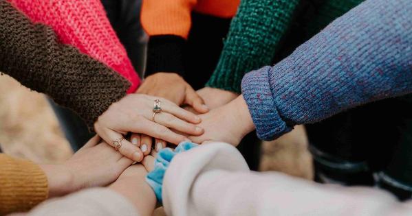 Multiple hands of various races joined together in a circle. 