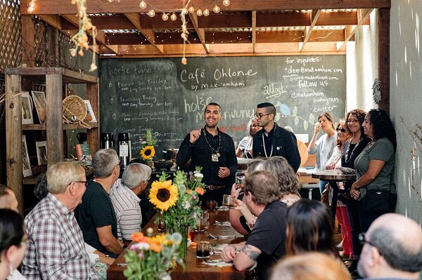 photo of people in a dining room, chalkboard menu, feasting