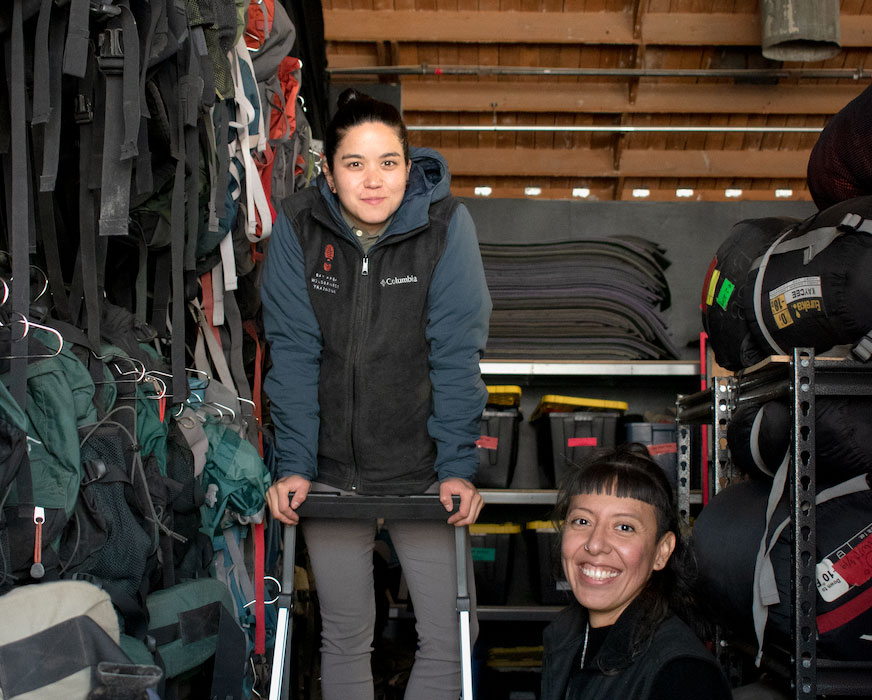 photo of people in a warehouse-like facility full of outdoor gear
