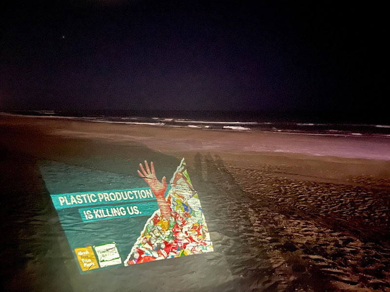 photos of a beach at night, words plastic pollution projected on the sand