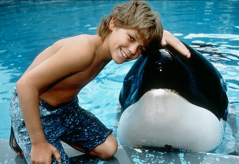 a young person posing with a captive orca