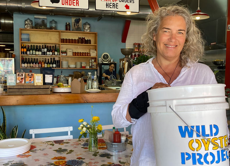 a person at an oyster bar with a bucket