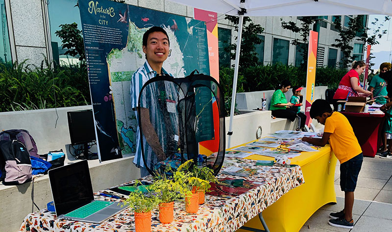 photo of a young man at a table, displays and plants