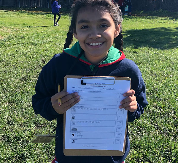 photo of a child outdoors with a clipboard