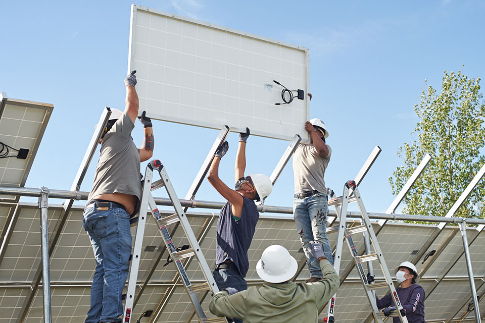 photos of people installing solar panels