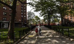 A woman walks with a child outside of a housing project in Brooklyn, New York, on May 19, 2020.