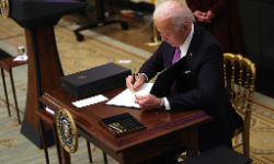 President Joe Biden signs an executive order during an event in the State Dining Room of the White House, January 21, 2021, in Washington. President Biden delivered remarks on his administration's COVID-19 response and signed executive orders and other presidential actions.