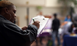 A job seeker fills out an application during a career fair in San Francisco, May 2014.