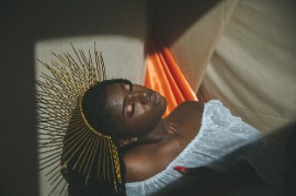 a Black woman wearing a spiky gold crown