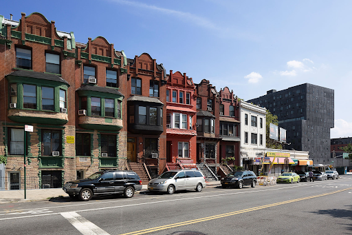 Row homes stand in front of an affordable housing development in New York's Harlem neighborhood