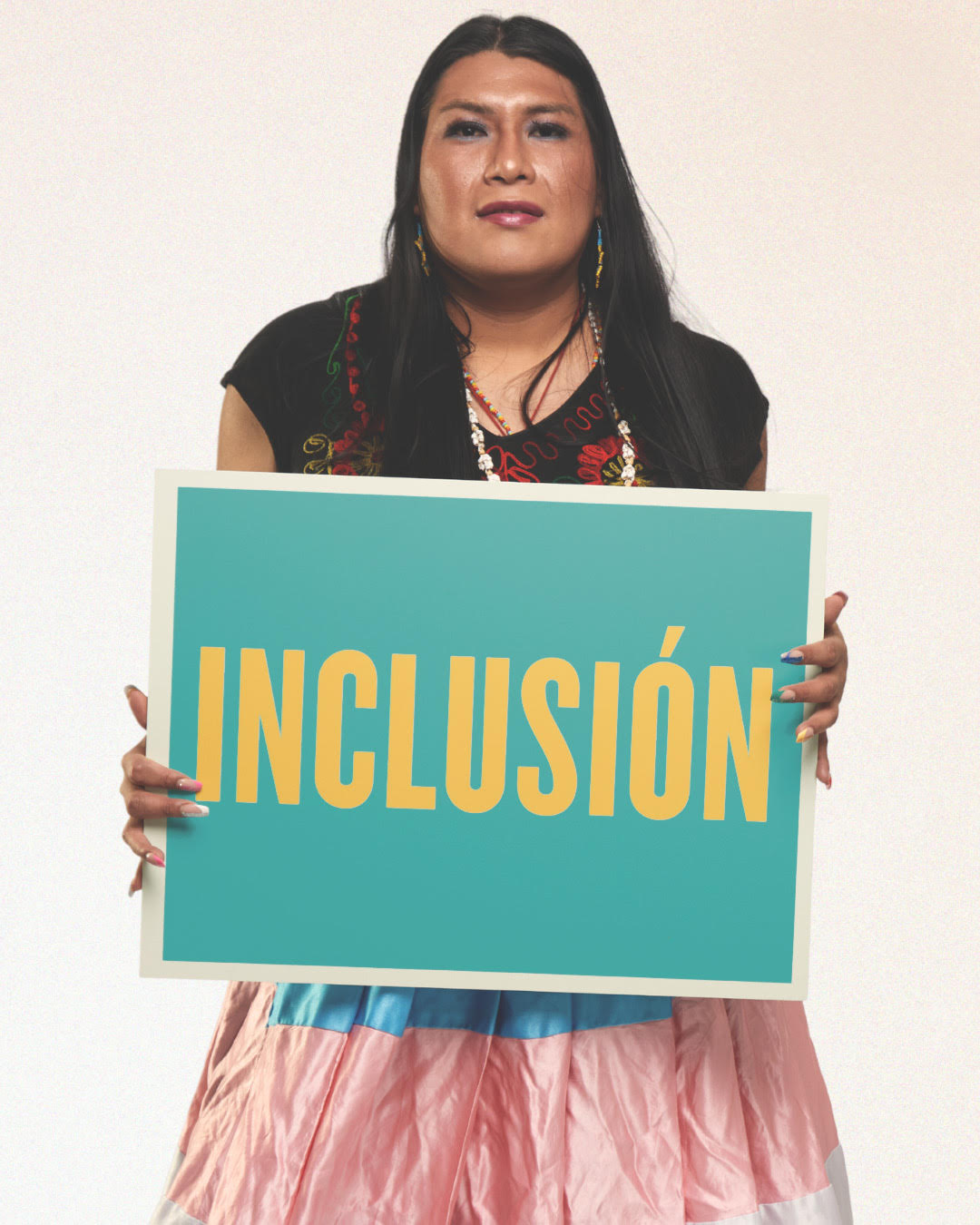 Photo of Li Ann holding a teal poster with the word "inclusion" in yellow