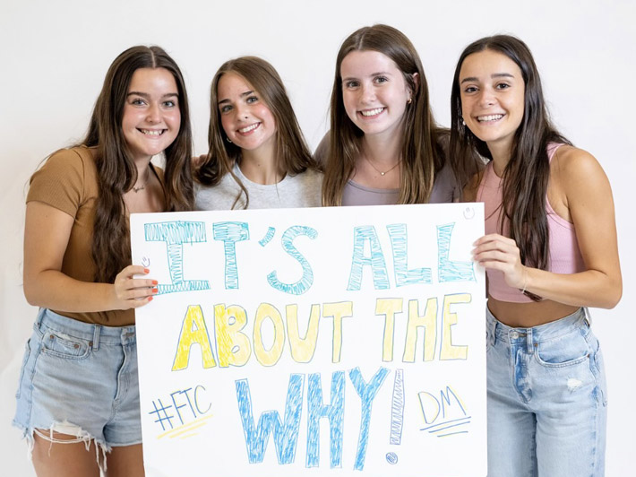 Four girls holding a fundraising signs