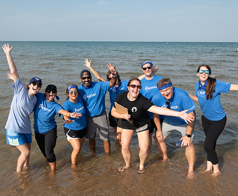 Corporate Cup team smiling and standing in water.