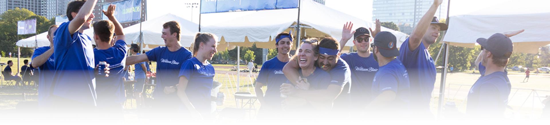 An adult team celebrating a win outside in the sun