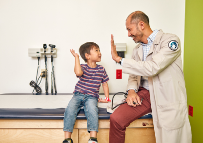 A doctor and child highfiving