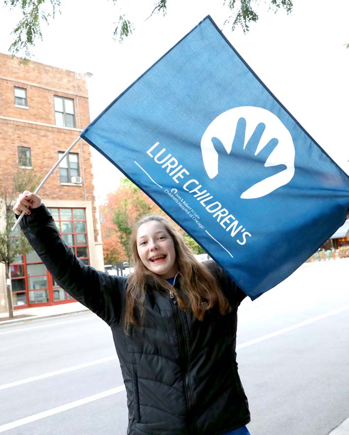 A spectator holding a Lurie Childrens flag