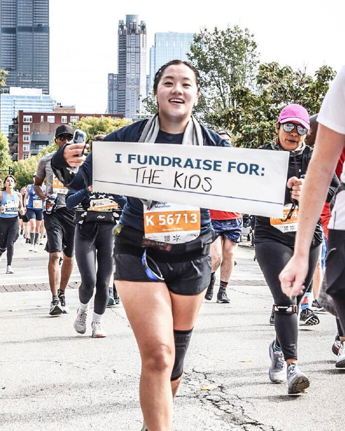 A marathon runner holding a sign.