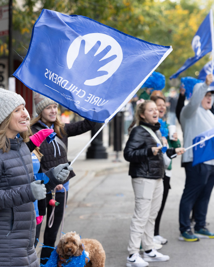 A spectator holding a Lurie Childrens flag