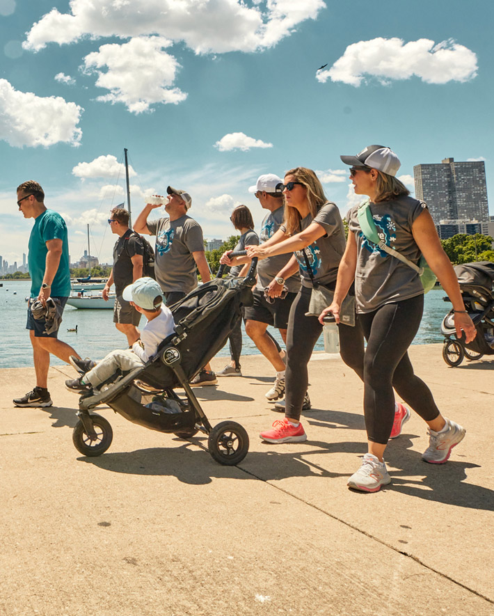 A group of people walking in the harbor.