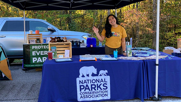 person standing behind a table waving
