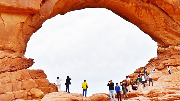 crowds of people visit a natural landbridge at Arches NP