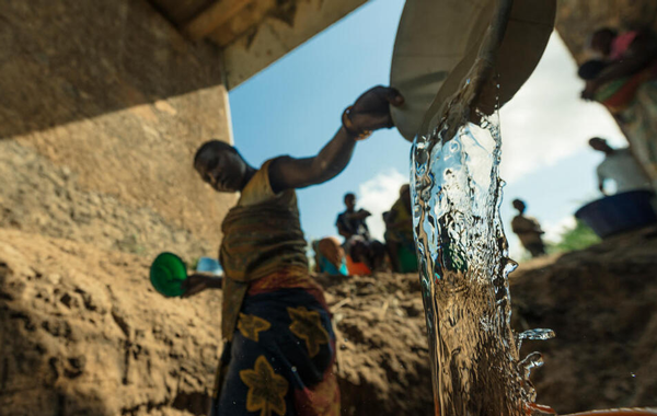 Group of people gathered around to access groundwater