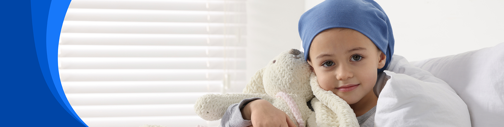 young child in bed holding stuffed animal