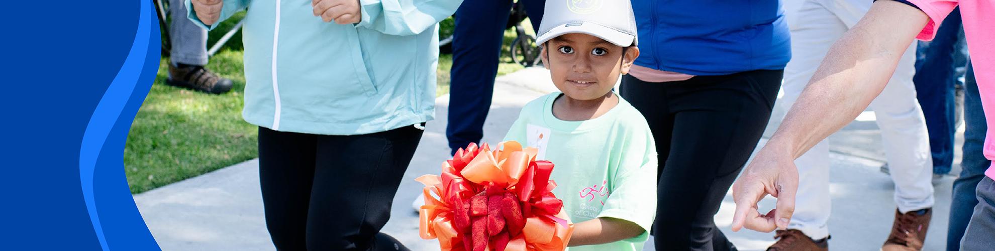 young child holding ribbon torch