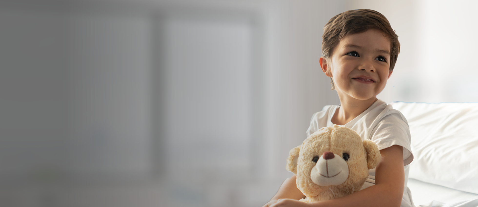 Smiling boy holding teddy bear