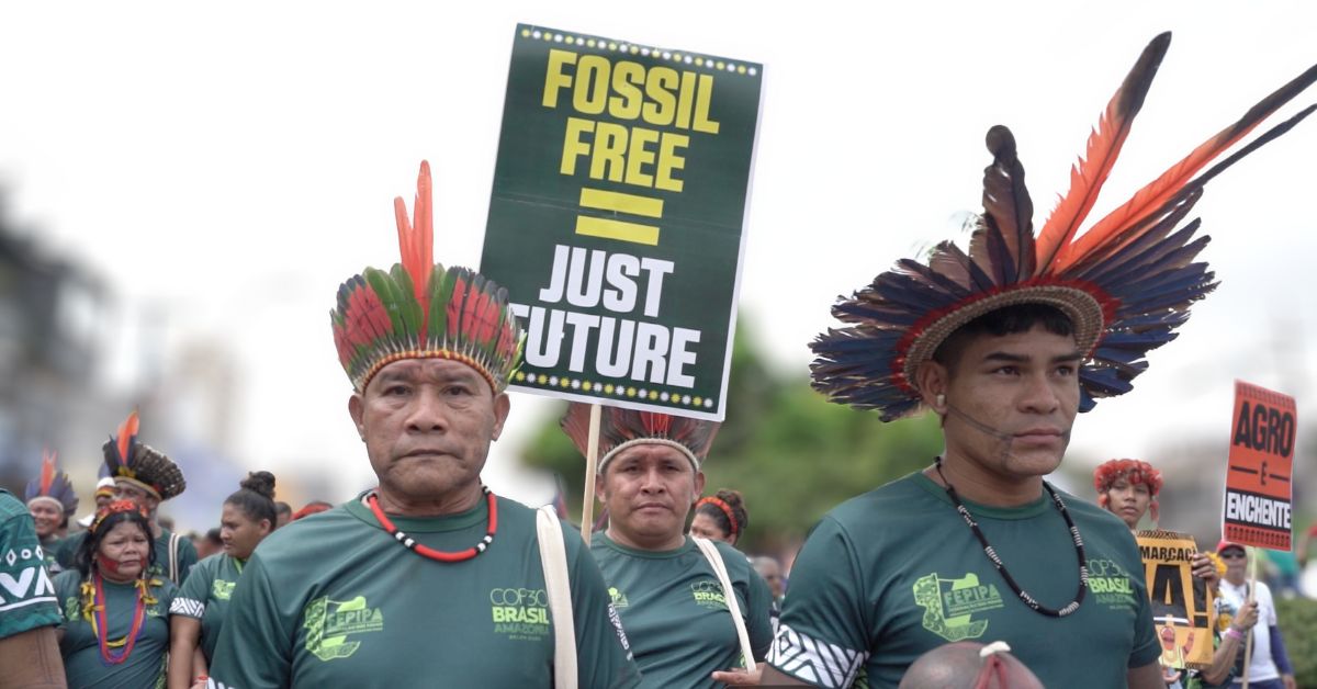 Indigenous activists marching, one holding a 