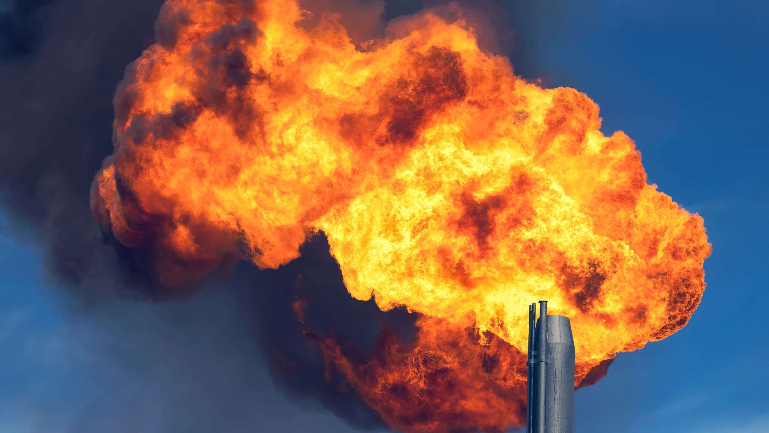 Smoke spews from an oil refinery. 