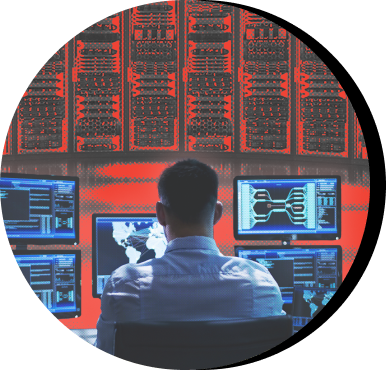 Person working on computers with a data center in the background